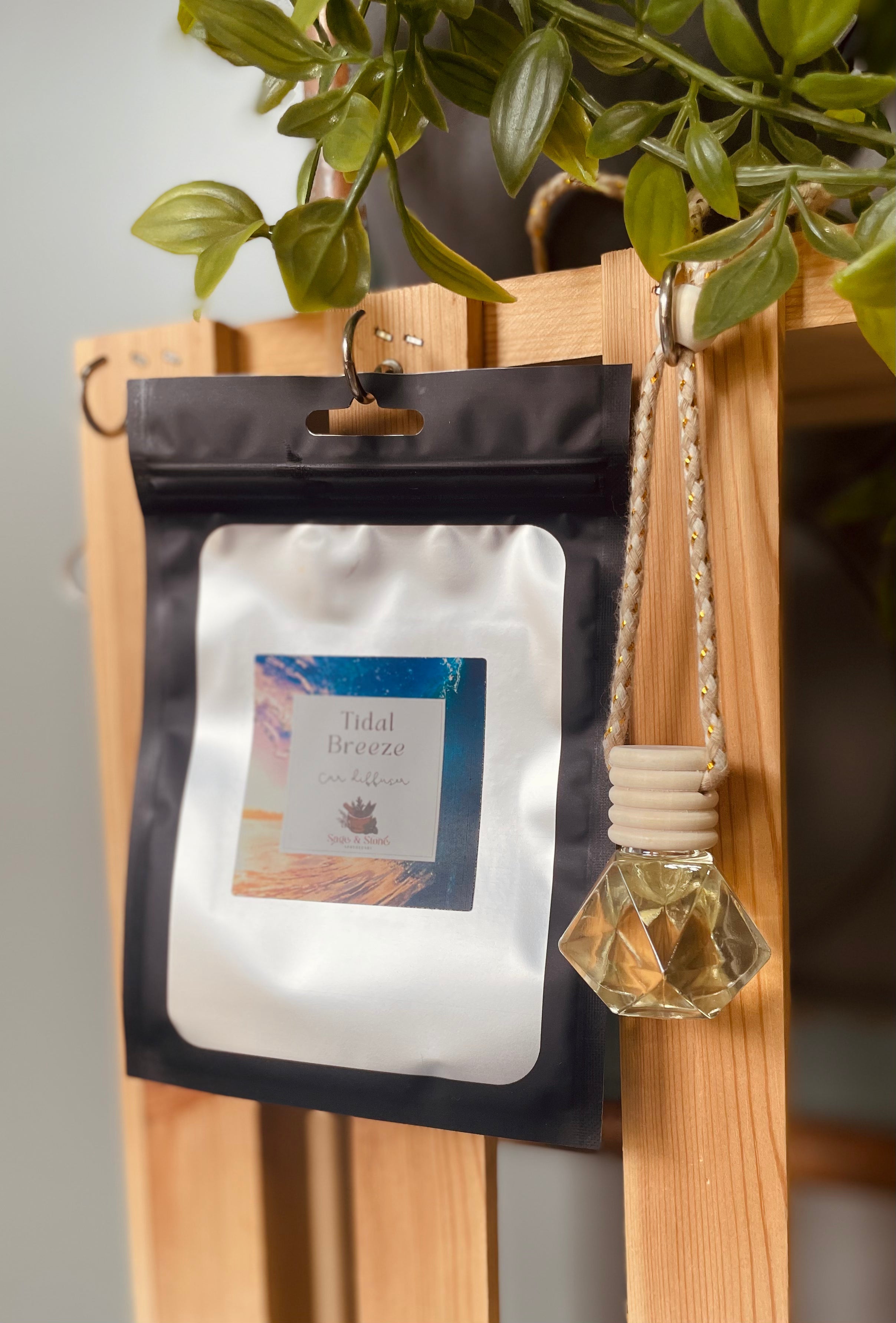 Sage & Stone Apothecary Tidal Breeze car diffuser with ceramic design and wooden accents hanging in a vehicle interior.