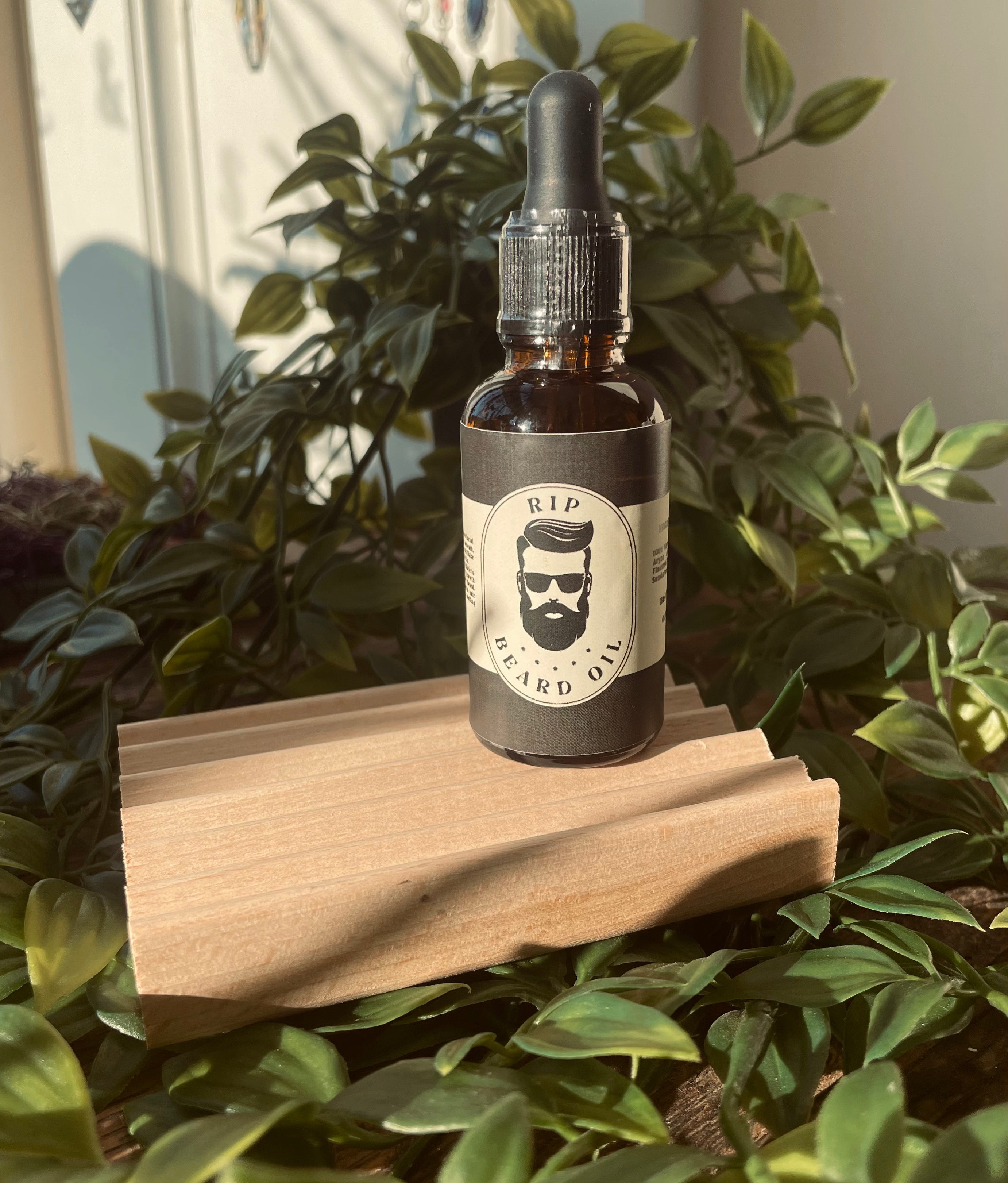 Men's RIP Beard Oil from Sage & Stone Apothecary, featuring a dark glass bottle with a dropper for beard grooming.