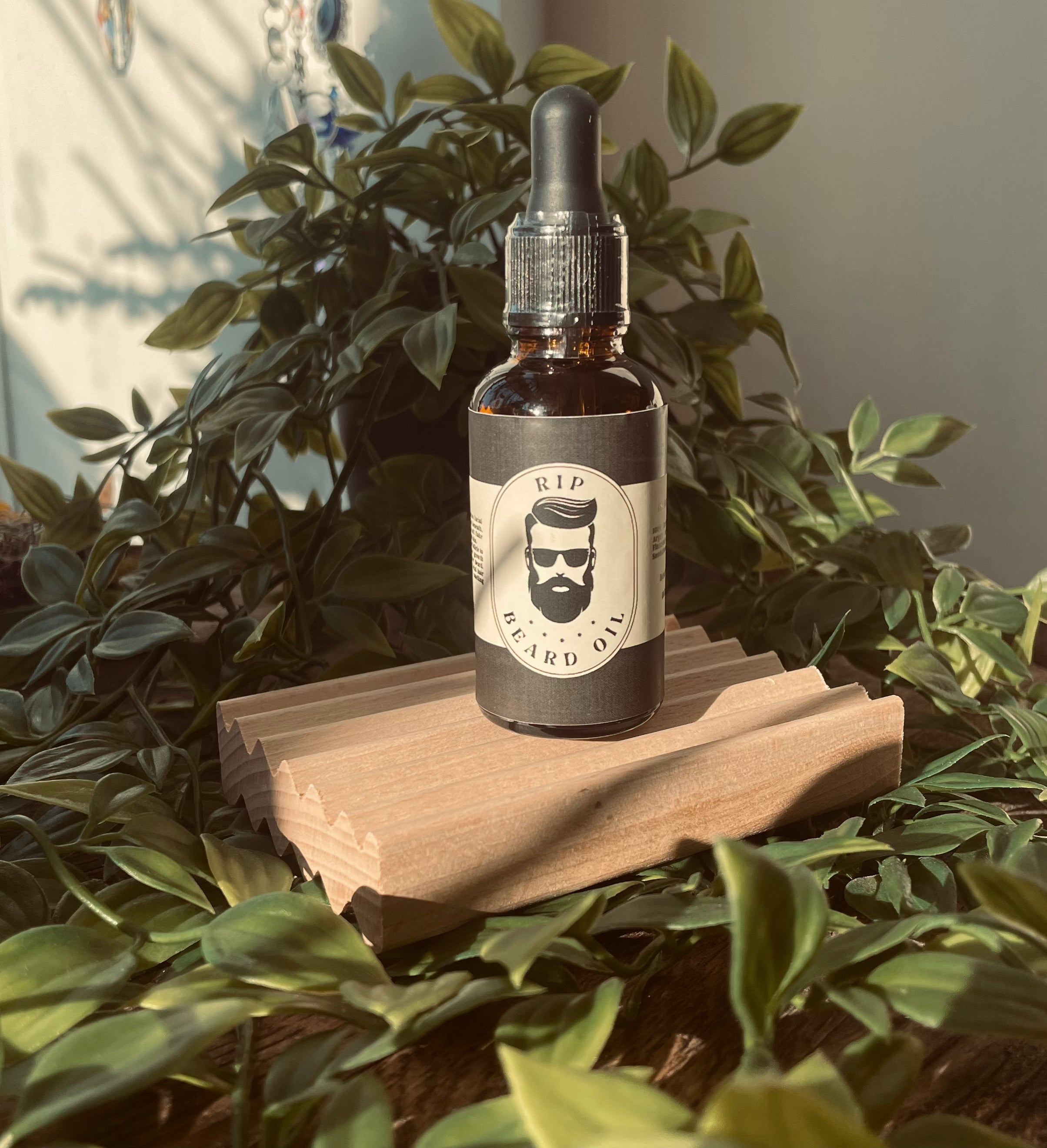 Men's RIP Beard Oil by Sage & Stone Apothecary, close-up of dark glass bottle with dropper for beard grooming.