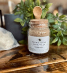 Brown Sugar Chamomile Scrub by Sage & Stone Apothecary, showing a jar of exfoliating personal care scrub with chamomile flowers and brown sugar.