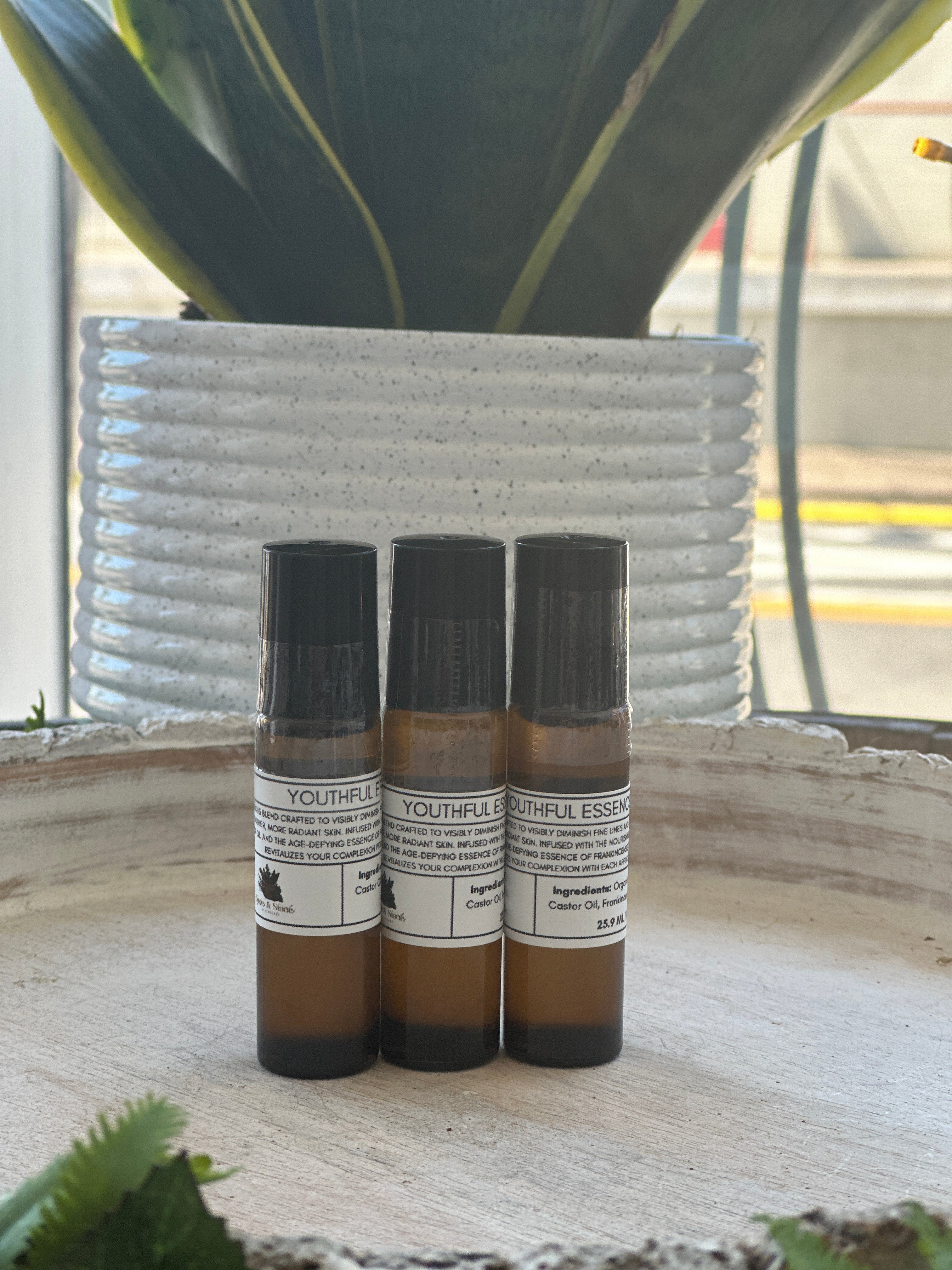 Sage & Stone Apothecary Youthful Essence Roll-On for personal and body care, featuring a clear glass bottle with a metal rollerball applicator.