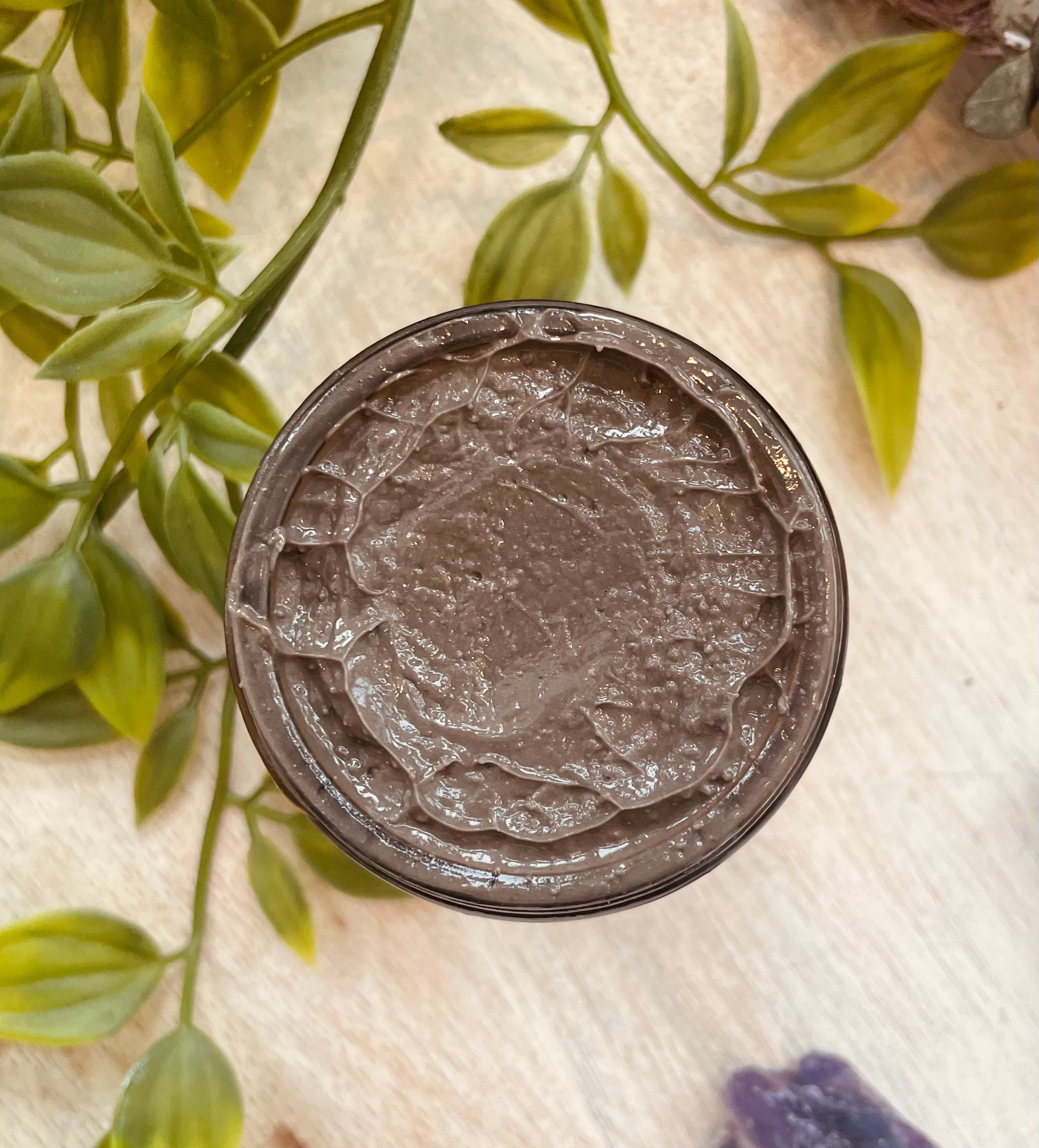 Sage & Stone Apothecary Dead Sea Black Mud Mask applied on face for skincare and wellness, with a natural, earthy appearance.