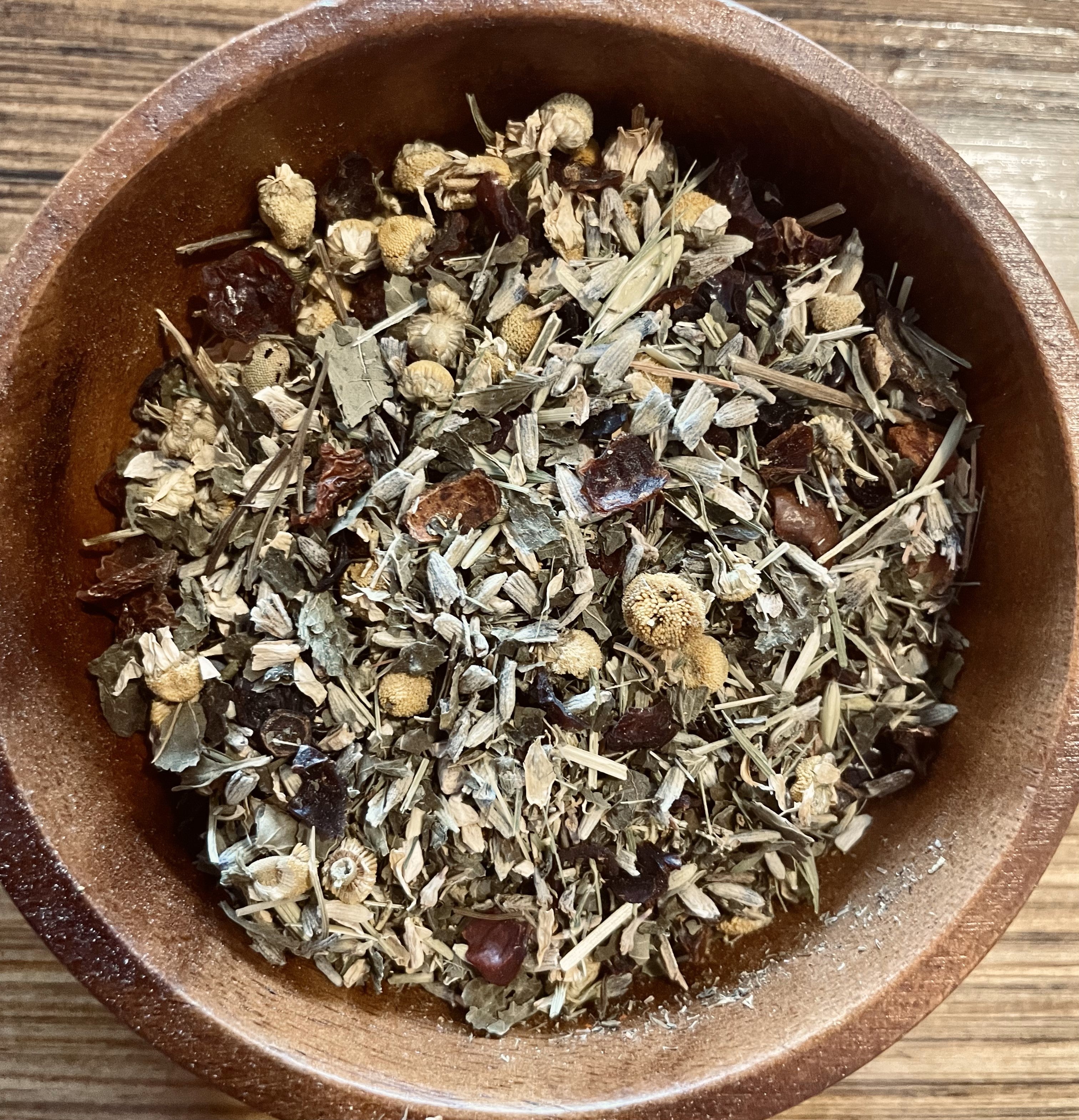 Sage & Stone Apothecary anti-anxiety tea in a clear glass cup with herbs and steam, promoting relaxation and calmness.