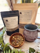 Sage & Stone Apothecary Cold Defender tea in a glass cup, featuring herbal ingredients and a warm, soothing appearance.