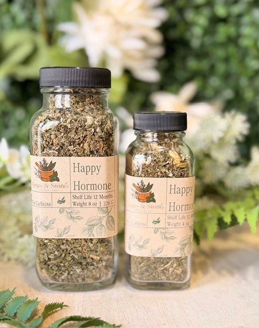 A cup of Sage & Stone Apothecary Happy Hormone Balance Tea with tea leaves and herbs, ready for brewing.