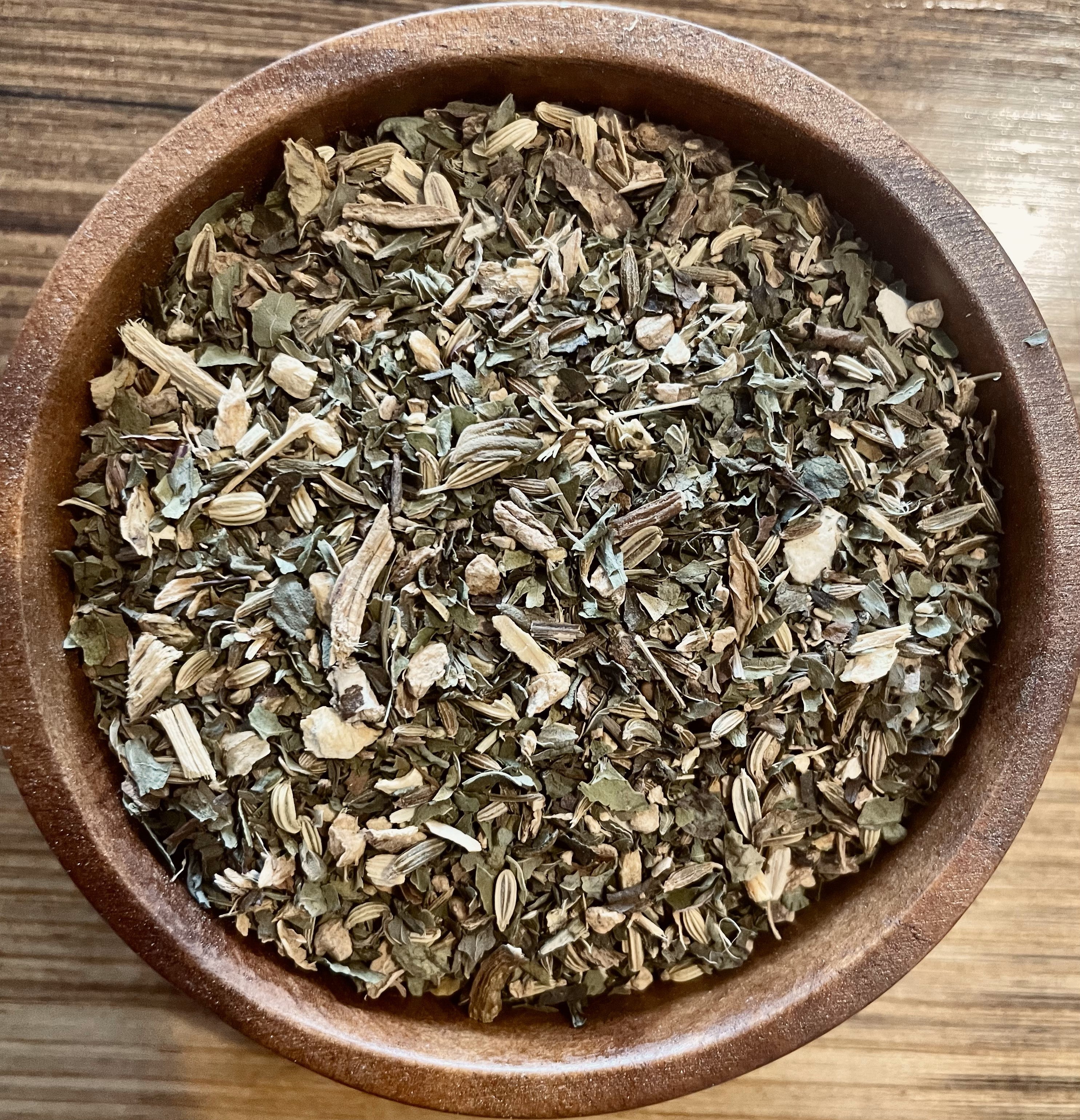 Sage & Stone Apothecary Digest Blend tea in a glass mug, showcasing herbal tea with fresh herbs and a steaming cup.
