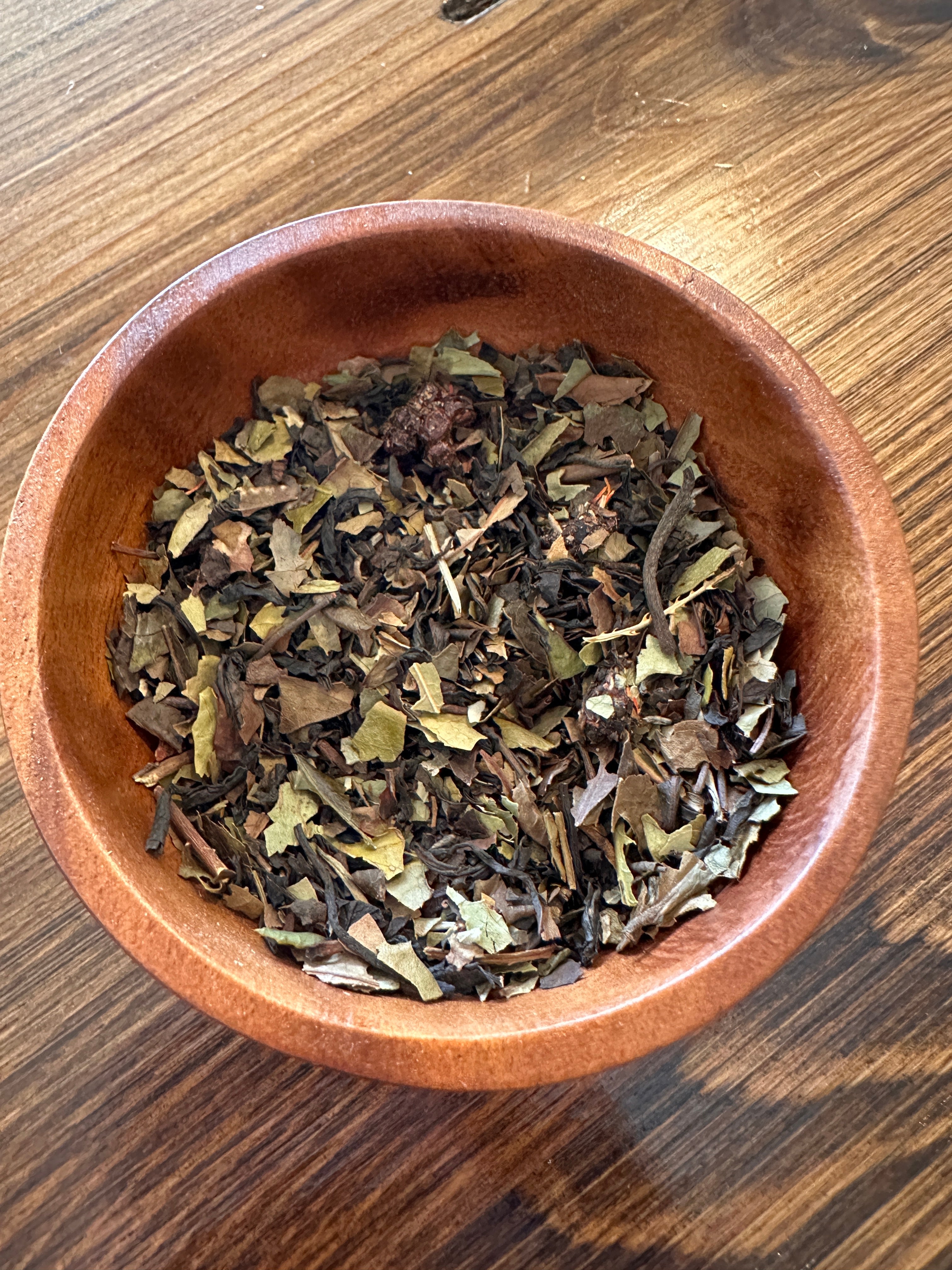 Sage & Stone Apothecary Flo Herbal Tea in a glass mug, showcasing a vibrant herbal blend with fresh herbs and dried flowers.