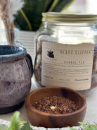 Glass slipper-shaped tea infuser from Sage & Stone Apothecary, designed for brewing loose leaf tea in a charming glass container.