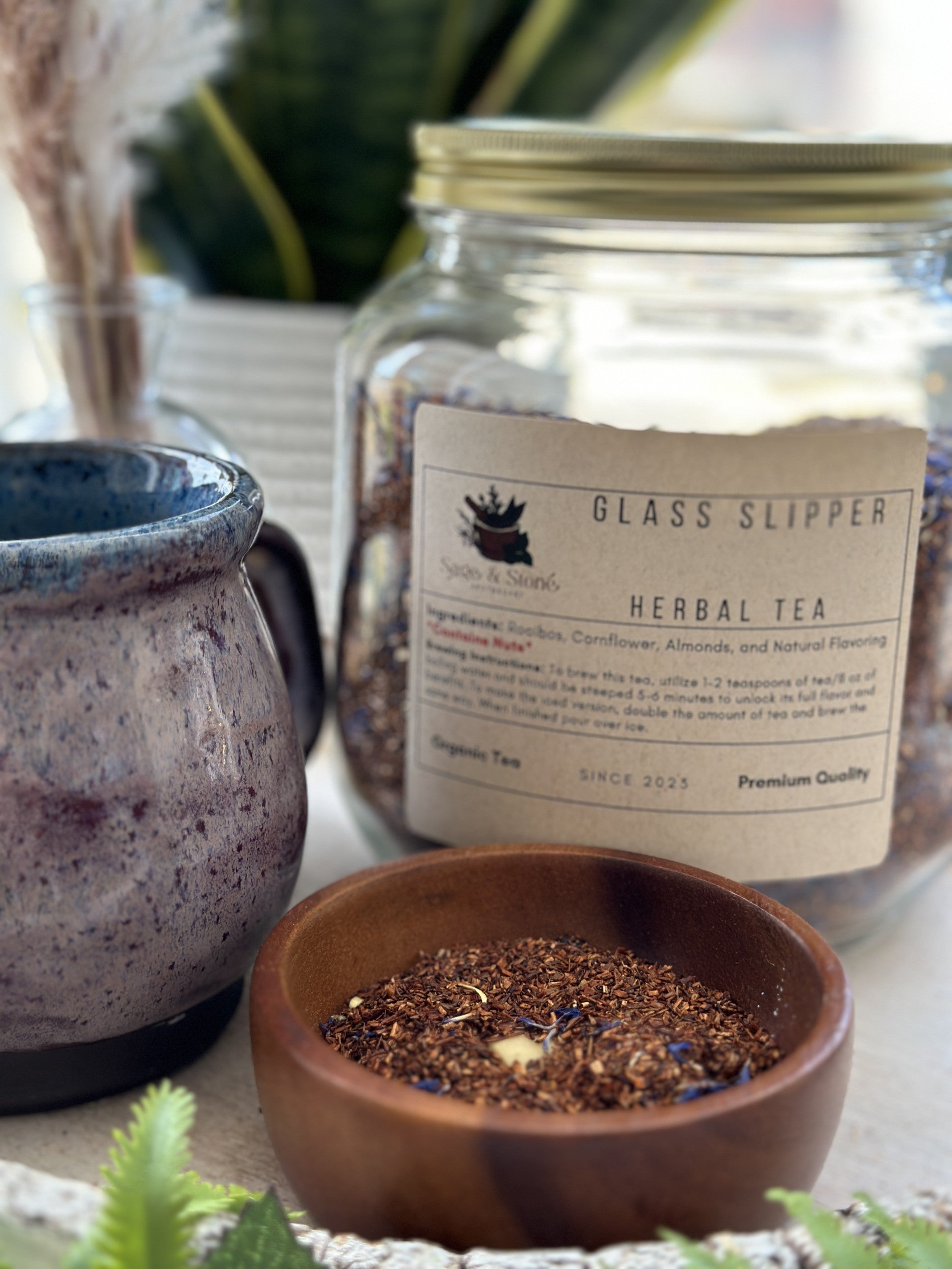 Glass slipper-shaped tea infuser from Sage & Stone Apothecary, designed for brewing loose leaf tea in a charming glass container.