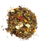 Glass cup of Peach Raspberry Punch tea from Sage & Stone Apothecary with fresh peach and raspberry slices visible inside.