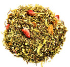 Cup of Sage & Stone Apothecary strawberry, orange, and peach flavored tea in a clear glass mug on a wooden surface.
