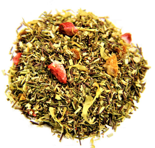 Cup of Sage & Stone Apothecary strawberry, orange, and peach flavored tea in a clear glass mug on a wooden surface.