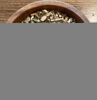 Sage & Stone Apothecary Detox Blend tea in a clear glass cup with loose herbal tea leaves and dried herbs visible.