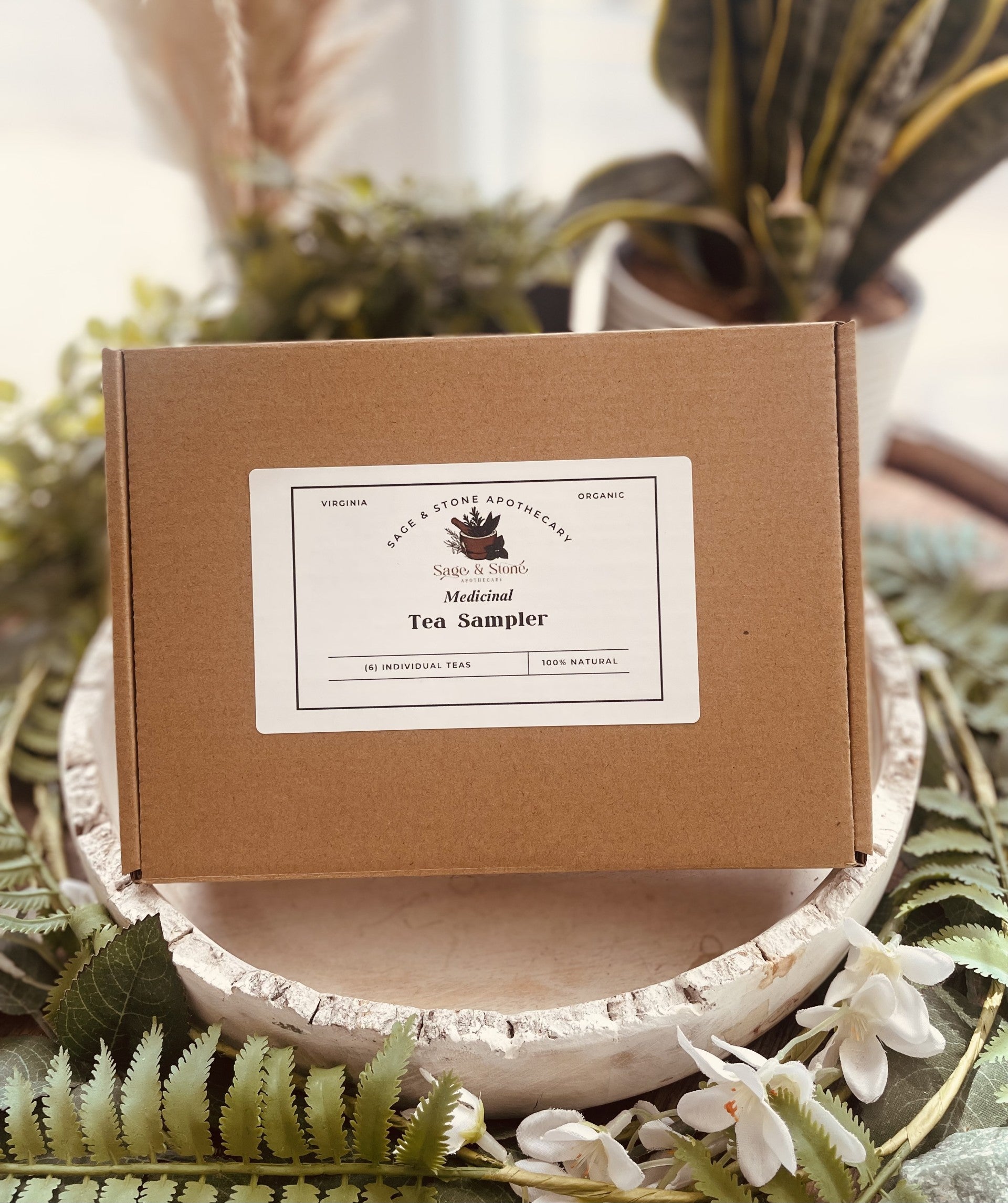 Assorted tea and infusion sampler set from Sage & Stone Apothecary, featuring herbal teas in decorative packaging.