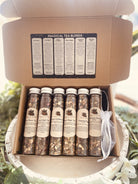 Assorted tea and infusion sampler set from Sage & Stone Apothecary with witchy-themed packaging for gifts and kitchen magic.