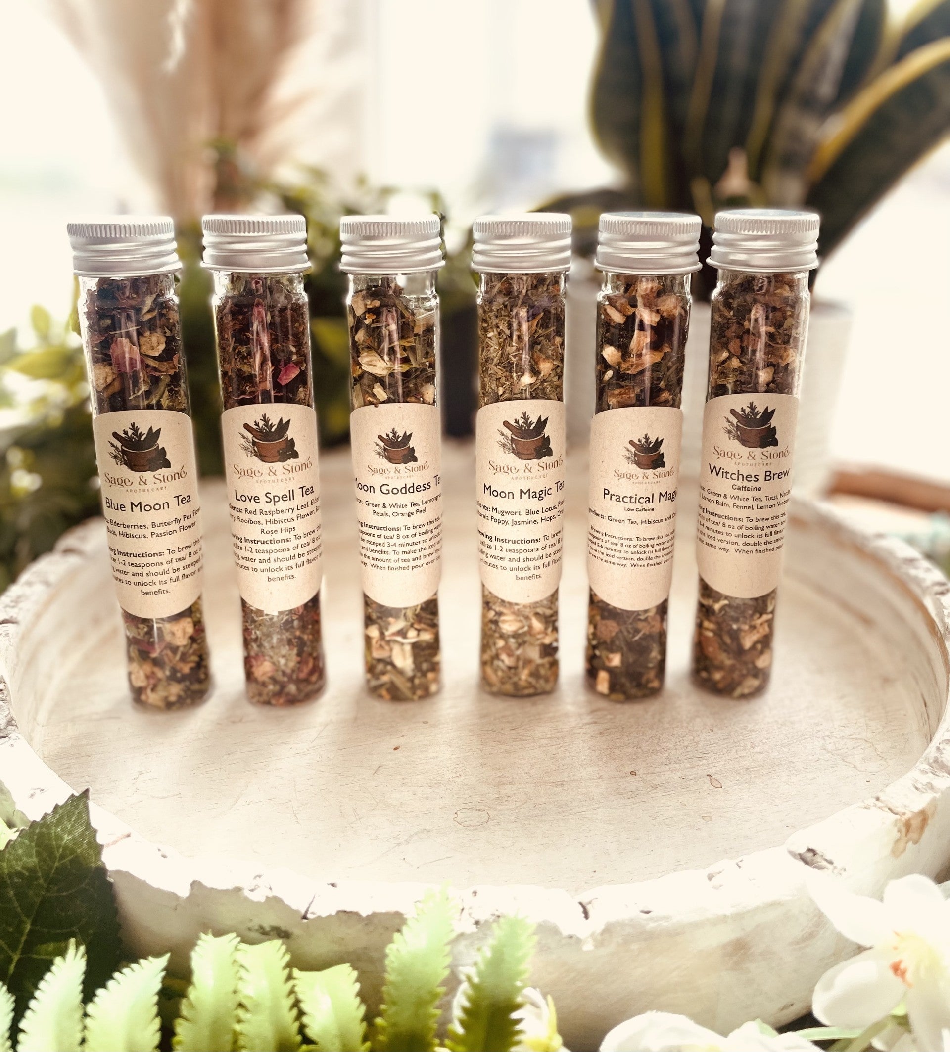 Assorted tea sampler sets from Sage & Stone Apothecary featuring tea and infusion blends in decorative packaging.