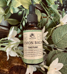 Lemon balm tincture in a glass bottle with dropper from Sage & Stone Apothecary, labeled for herbal remedy use.