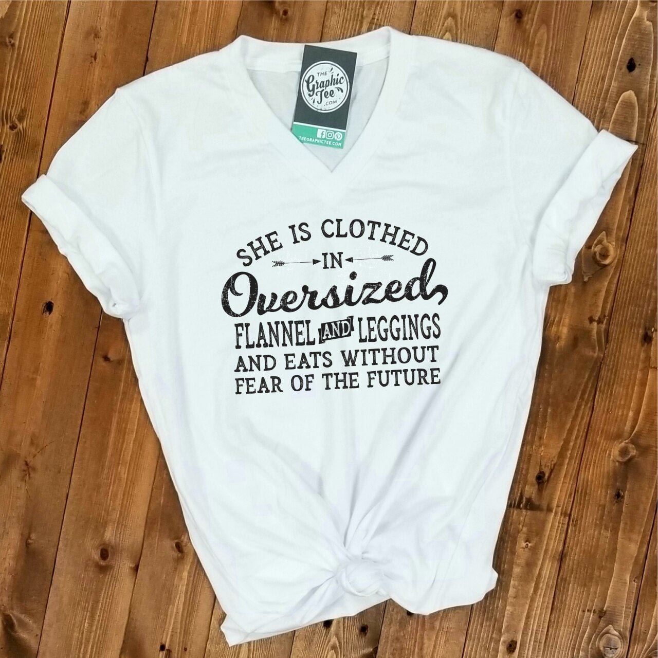 Woman wearing oversized flannel, leggings, and a V-neck graphic tee from The Graphic Tee brand. Casual, cozy outfit.