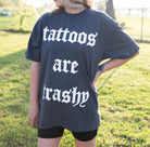Black graphic T-shirt from Shop Karma Tees with bold "Tattoos are Trashy" design on the front.