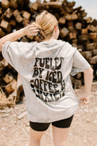 Black graphic tee featuring "Fueled by iced coffee and anxiety" slogan by Shop Karma Tees, casual wear with bold text design.