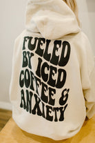 Graphical tee or sweatshirt featuring "Fueled by iced coffee and anxiety" slogan by Shop Karma Tees, with casual, comfortable design.