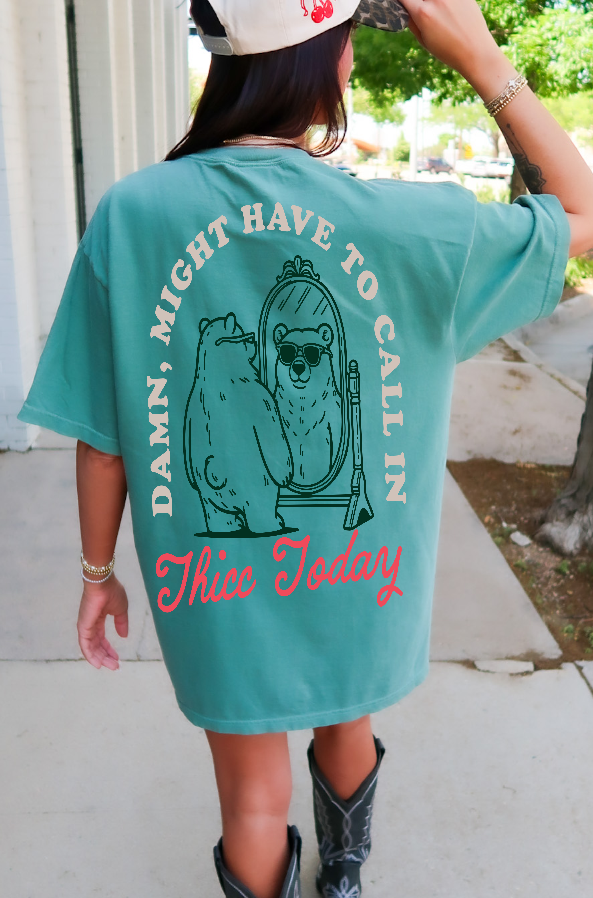Black graphic t-shirt featuring bold "Calling in Thicc" text on the front, from Shop Karma Tees.