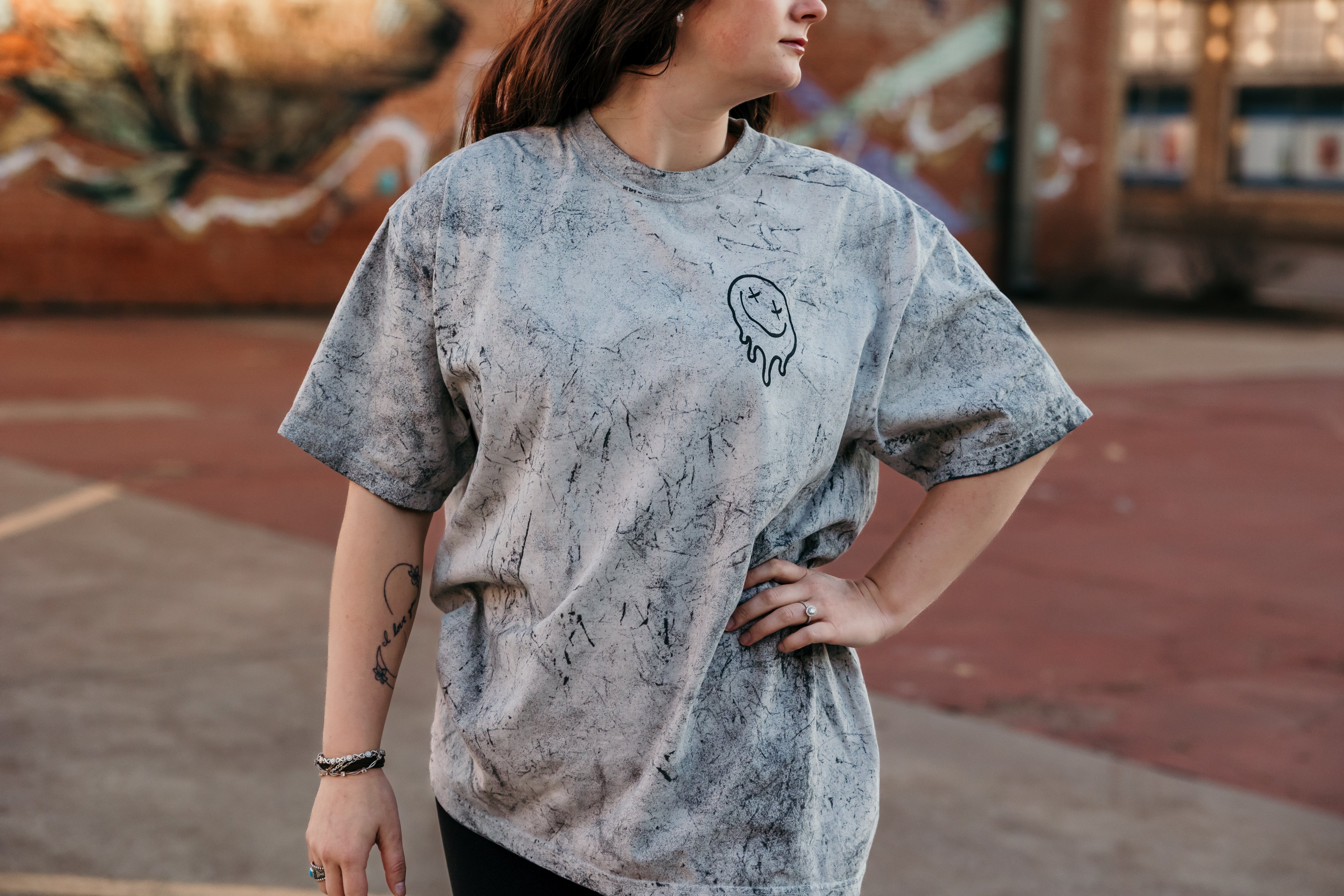 Overstimulated Moms Club graphic t-shirt from Shop Karma Tees, featuring bold text and casual fit, displayed on a hanger.