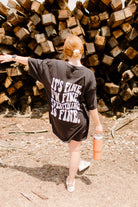 Black "It's Fine" graphic T-shirt by Shop Karma Tees featuring bold white text on the front.