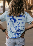 Silly Goose on the Loose graphic tee featuring a playful goose illustration, casual crewneck design from Shop Karma Tees.
