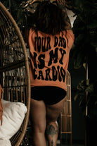 Graphic tee for men featuring "Your Dad Is My Cardio" design by Shop Karma Tees, shown on a casual model.