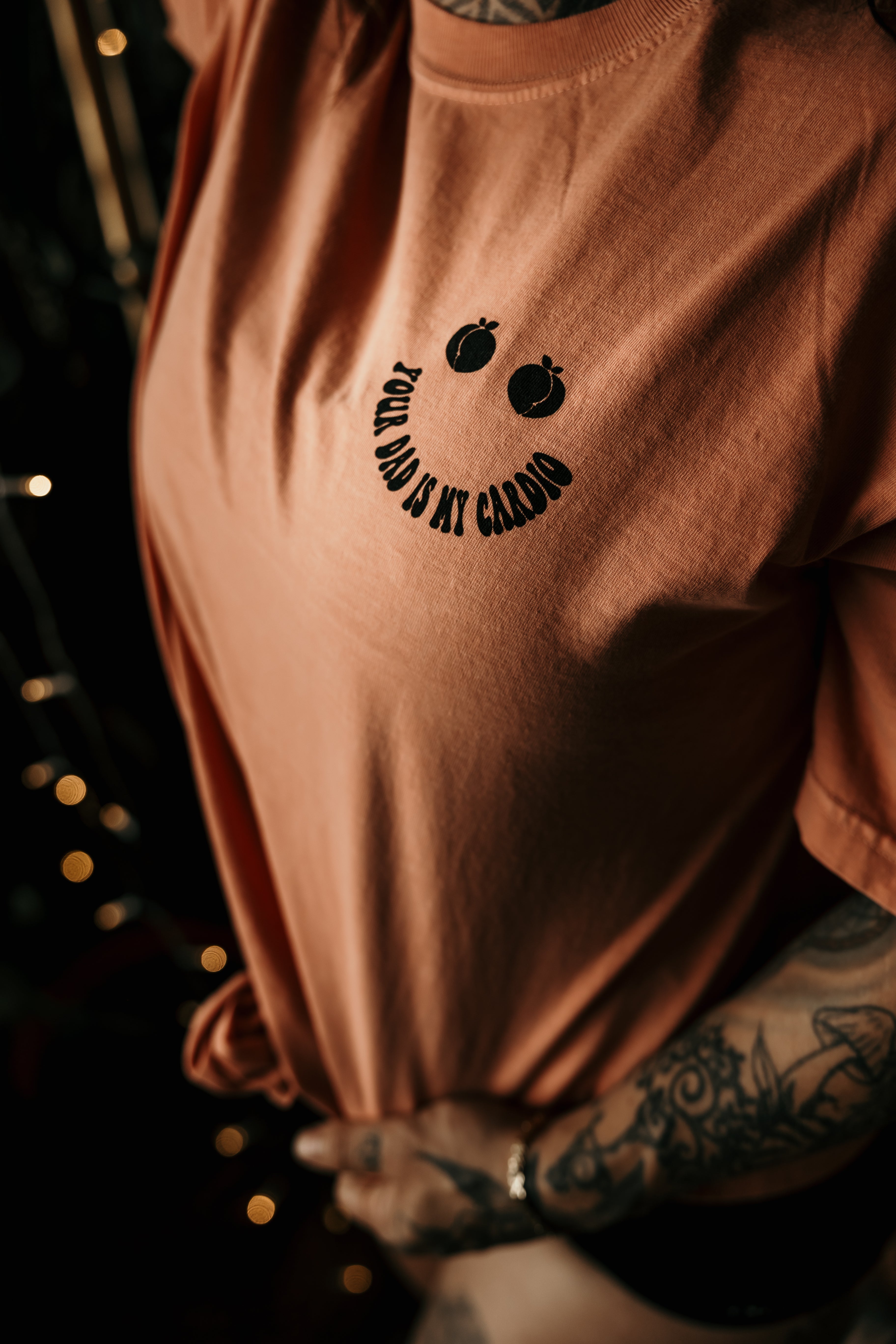 Gray graphic T-shirt from Shop Karma Tees featuring the humorous "Your Dad Is My Cardio" slogan printed on the front.