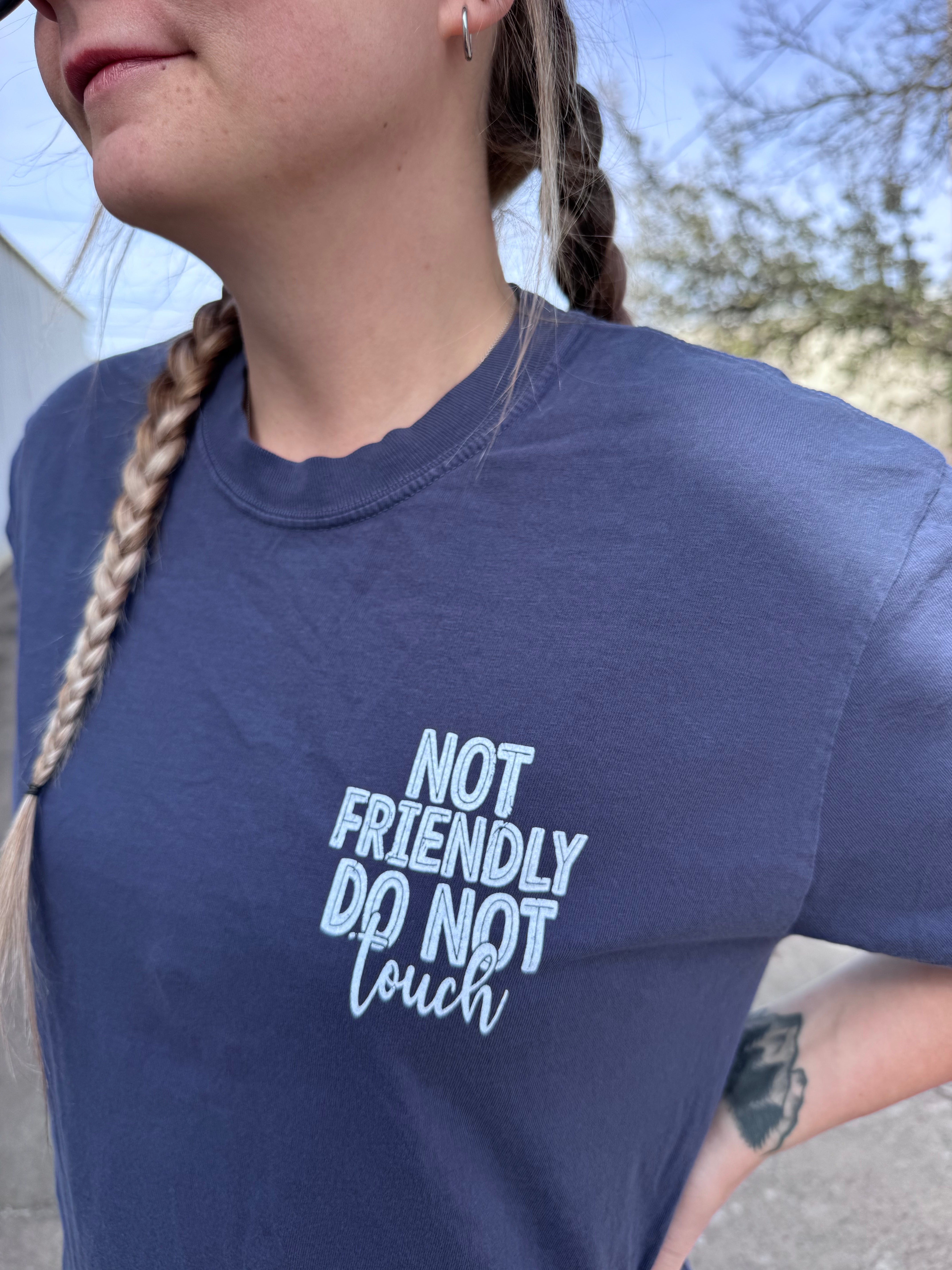 Men's "Not Friendly. Do Not Touch" graphic T-shirt by Shop Karma Tees shown flat on a surface with the design visible.