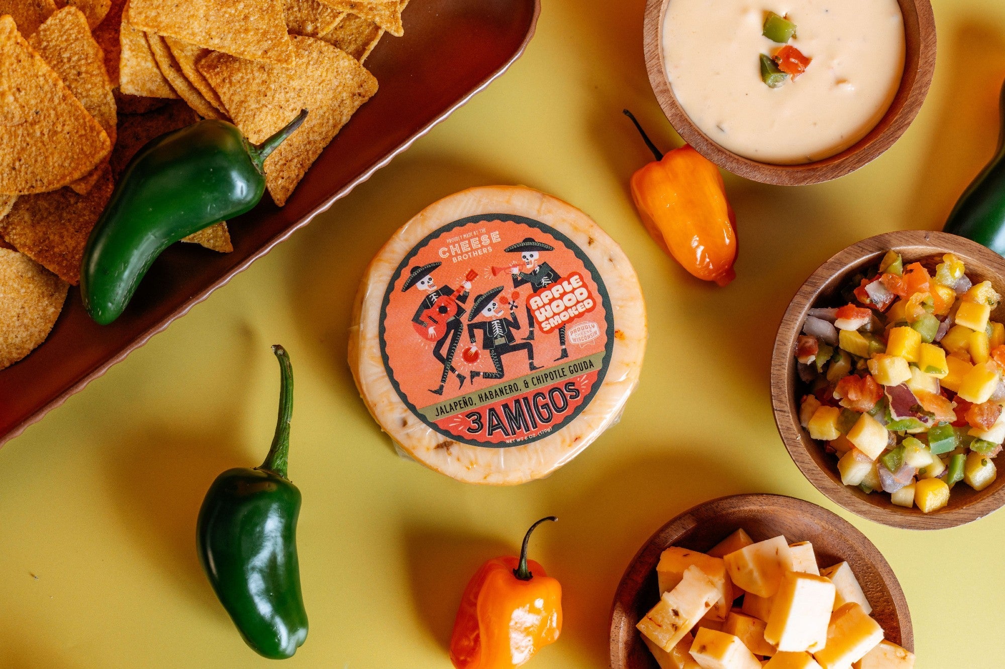 Smoked 3 Amigos spicy Gouda cheese block by Cheese Brothers, Inc. with a rich, smoked appearance and spicy seasoning visible.