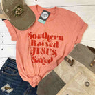 Unisex graphic T-shirt featuring Southern Raised and Jesus Saved design by The Graphic Tee, casual apparel for men and women.