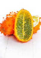 Orange Kiwano fruiting plant in a coconut coir pot by Sow Exotic, showcasing the vibrant fruit and lush green leaves.