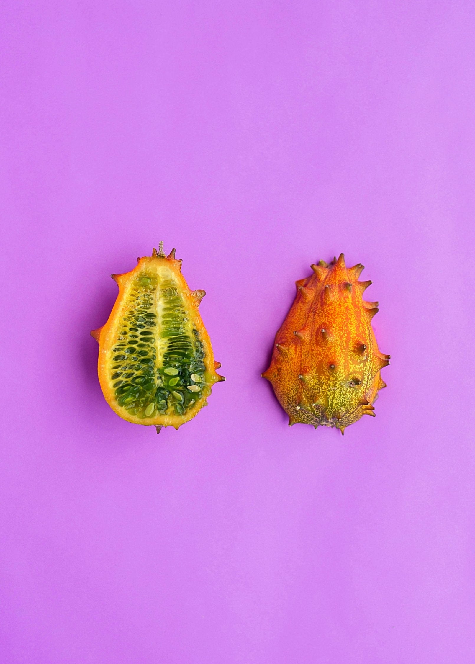 Orange Kiwano fruiting plant in a coconut coir pot, grown by Sow Exotic, showcasing the vibrant, spiky melon fruit.