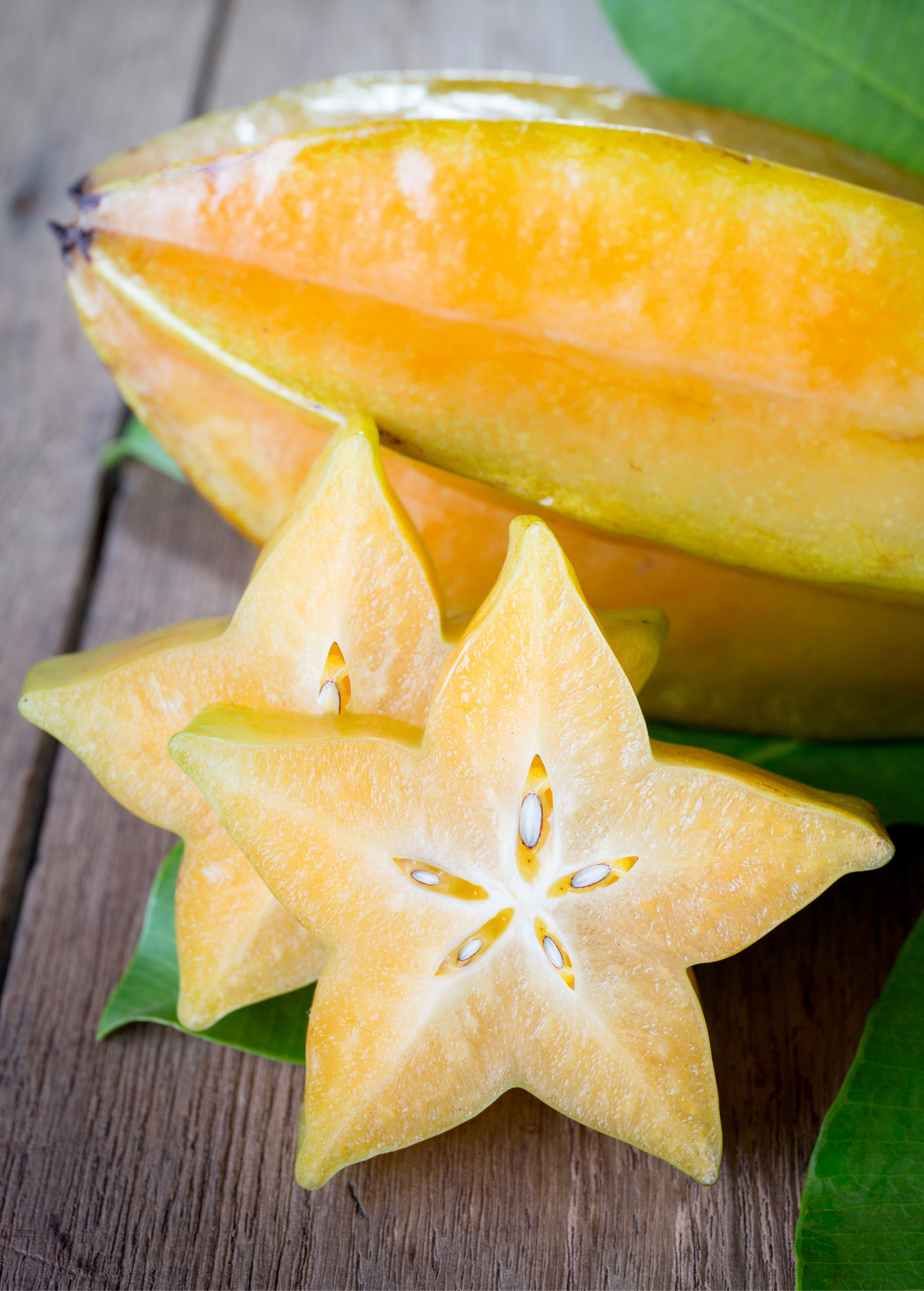 Large star fruit 'Arkin' tropical fruit tree in burlap pot, grown by Sow Exotic, showing lush green star-shaped fruit and foliage.