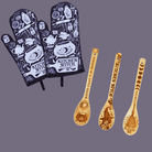 Purple and black kitchen witch oven mitt set with herbs design from Spirit Nest, featuring two heat-resistant mitts for cooking safety.