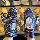 Purple and black Kitchen Witch oven mitt set with witch and herb design by Spirit Nest, perfect for kitchen use.