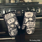 Purple and black Kitchen Witch oven mitt set with witch and herb design by Spirit Nest, perfect for kitchen safety and style.