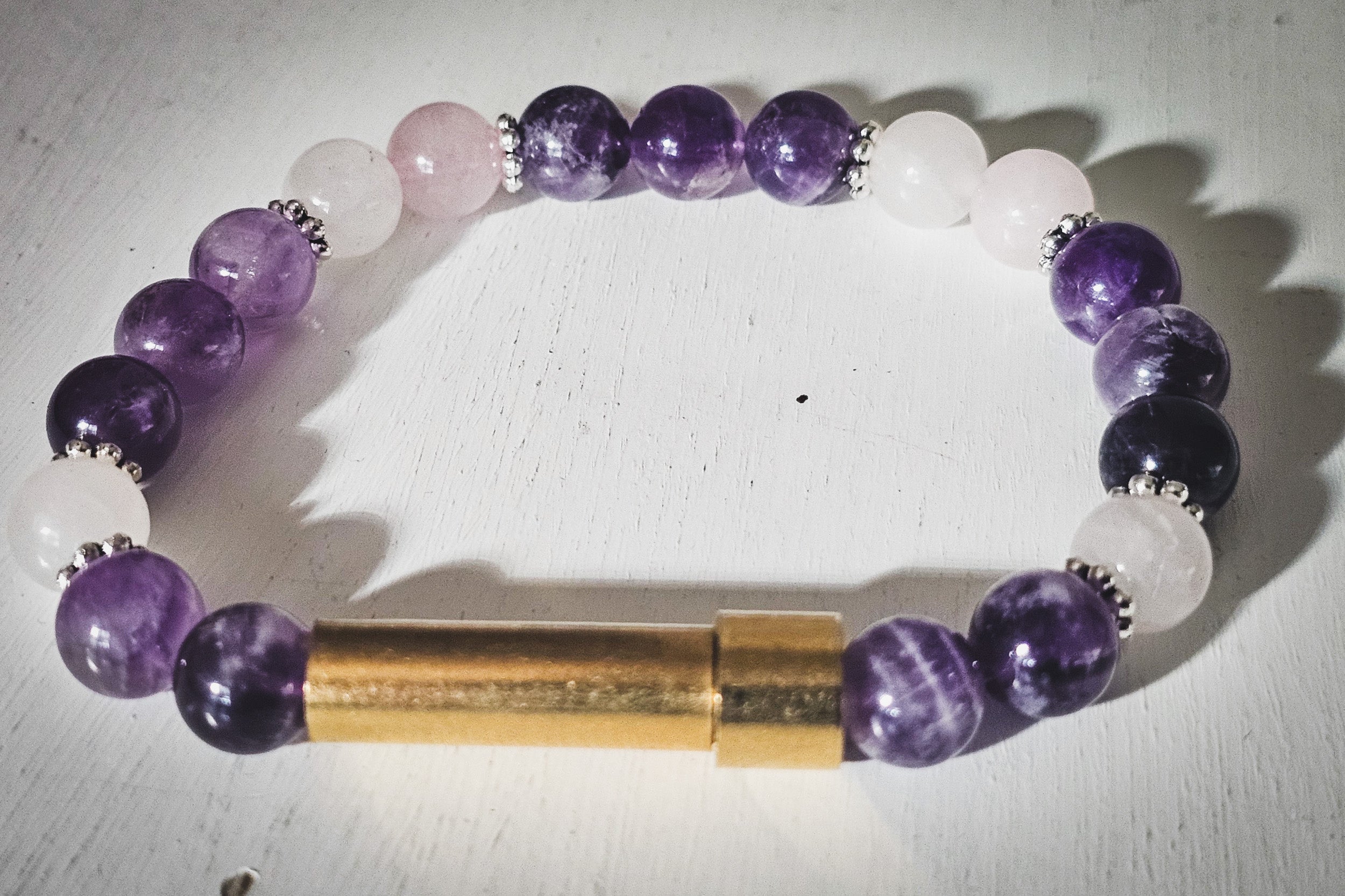 Silver cremation jewelry bracelet with amethyst and rose quartz stones, designed for hair, fur, or ashes. Spirit Pieces brand.