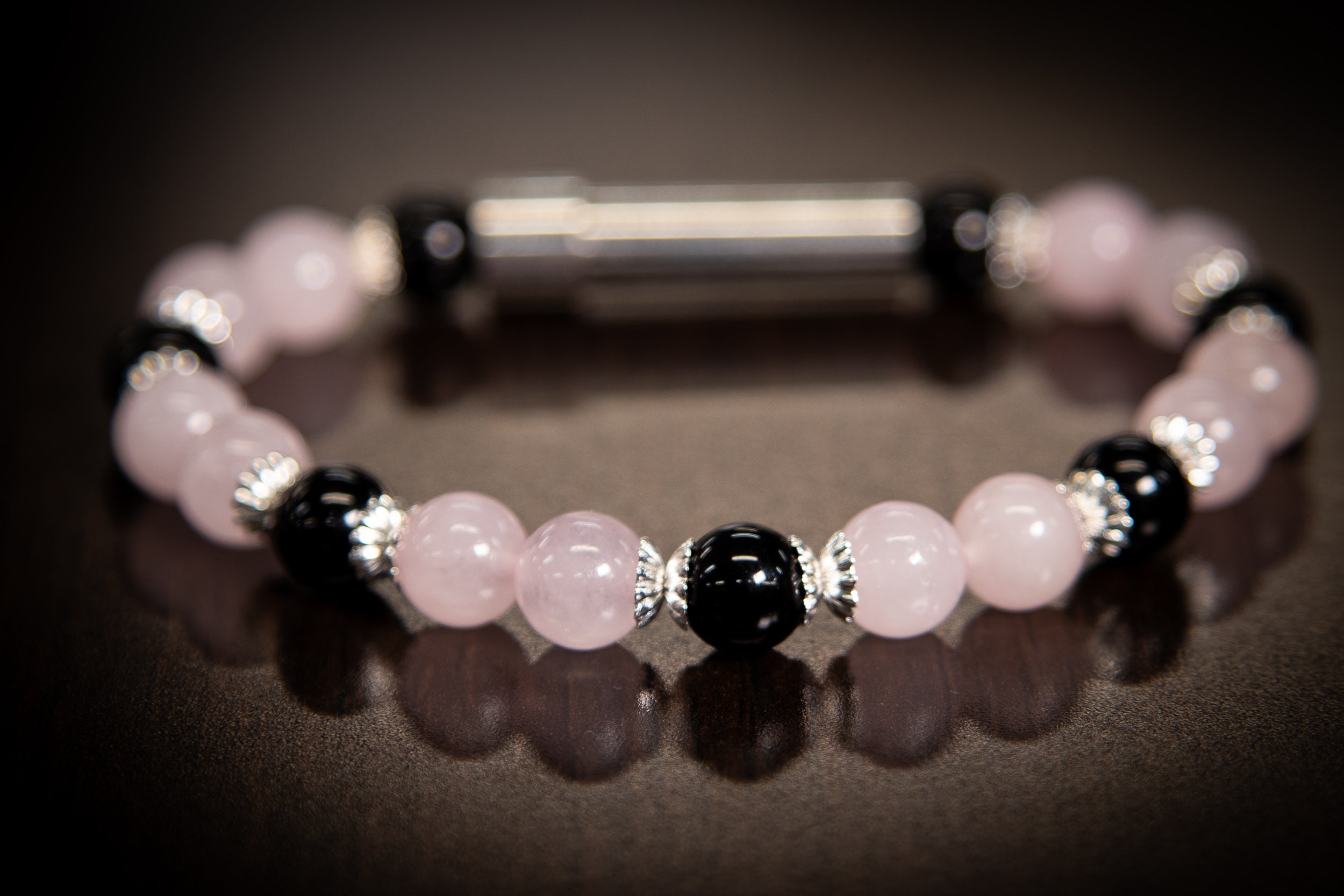Silver cremation jewelry bracelet with rose quartz and onyx beads, designed for hair, fur, or ash remembrance.