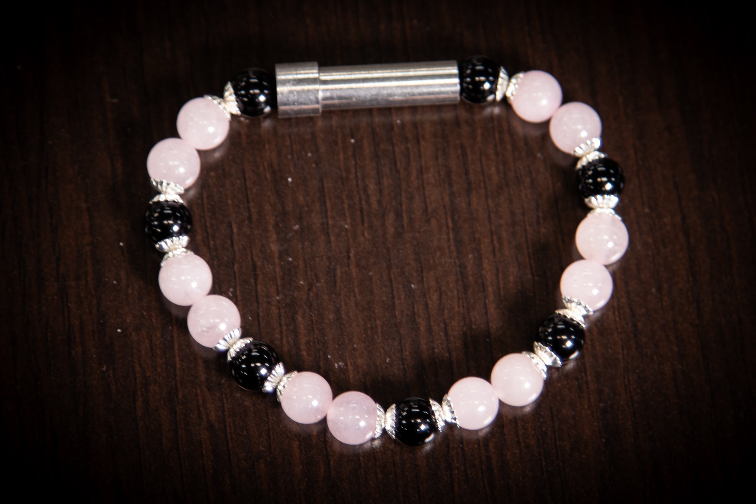 Silver cremation jewelry bracelet with rose quartz and onyx stones, designed for hair, fur, or ash keepsakes.
