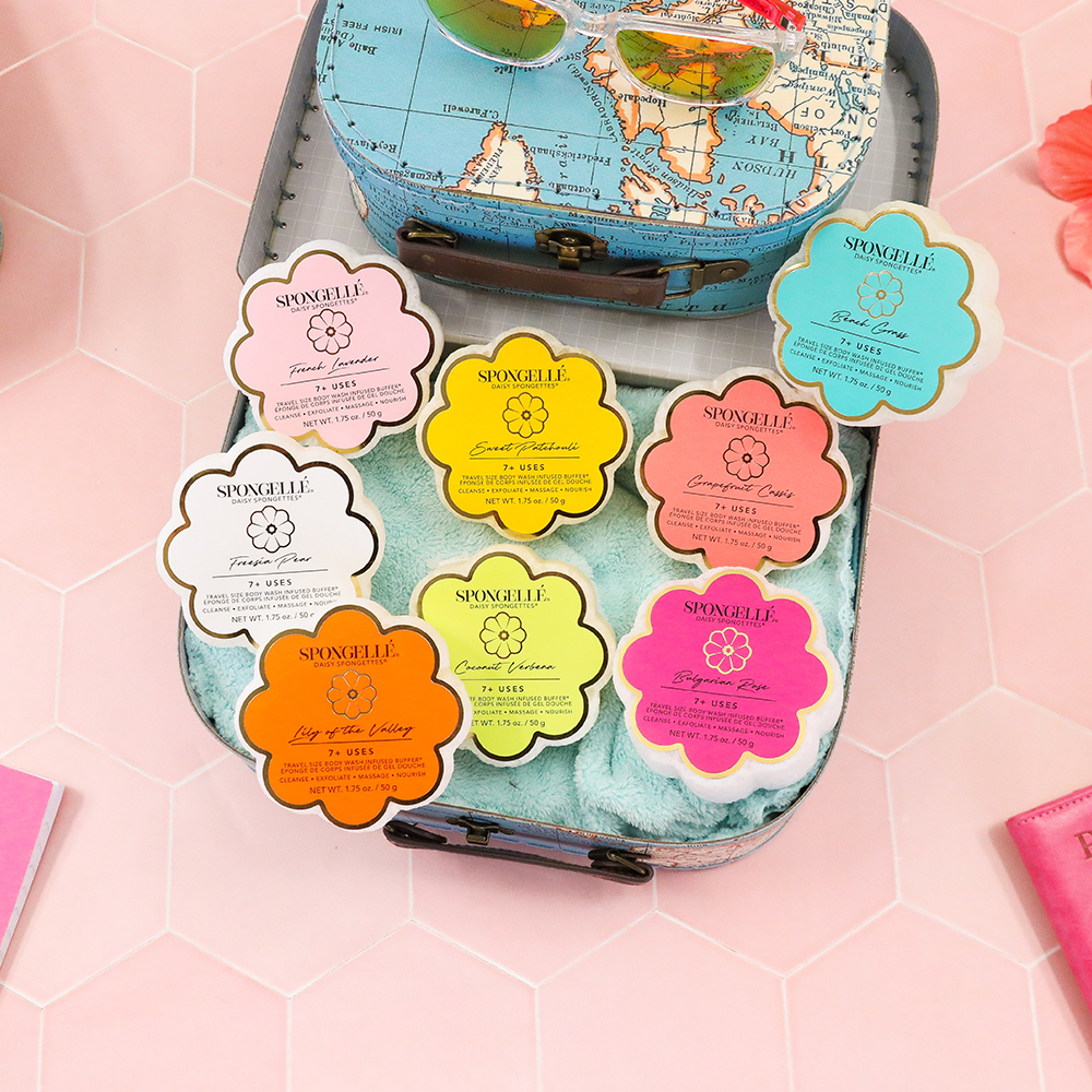 Assorted Daisy Spongette body wash infused buffers from Spongellé, colorful sponge buffers with floral design and textured surface.
