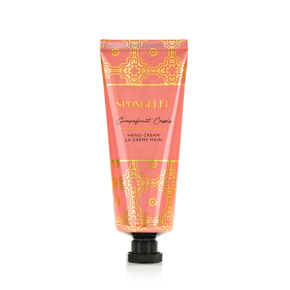 Spongellé Grapefruit Cassis hand cream tube with floral design, featuring bright orange and purple accents, on a white background.