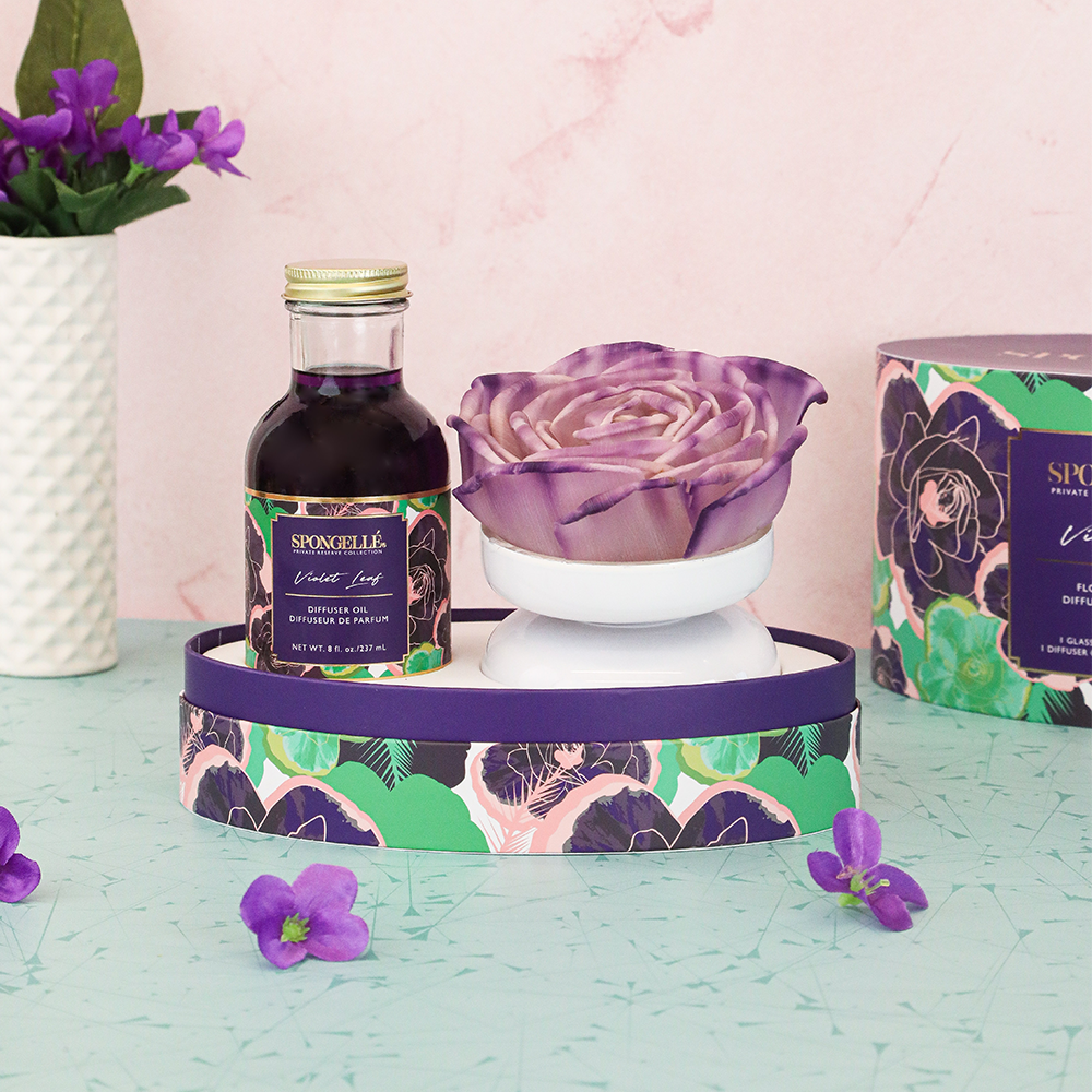 Violet Leaf Private Reserve diffuser by Spongellé, a home fragrance with a glass bottle and reed sticks for aromatic scent.
