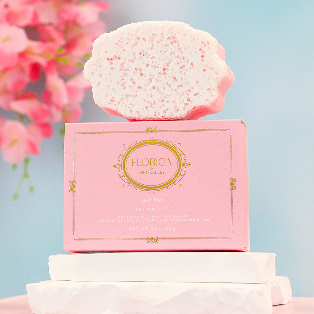 Spongellé Jude Rose Pedi Buffer by Florica, a pink and white textured handheld pedi buffer for foot exfoliation.
