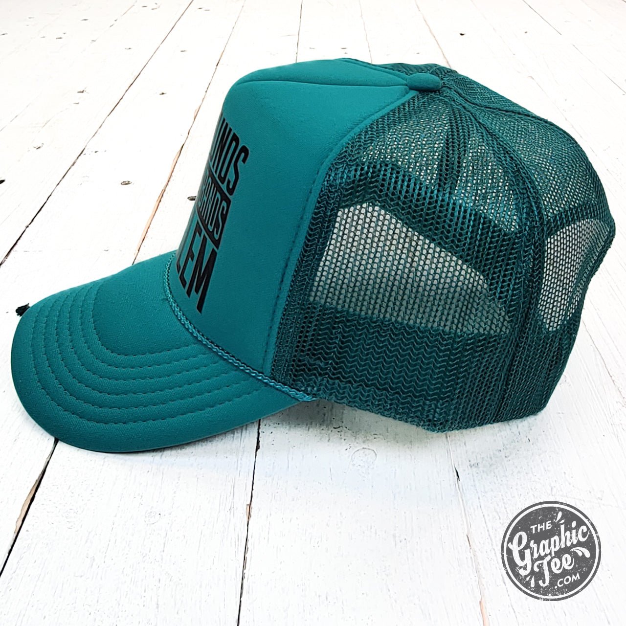 Jade foam trucker cap with "That Sounds Like My Husband's Problem" slogan by The Graphic Tee, adjustable mesh back, casual style.