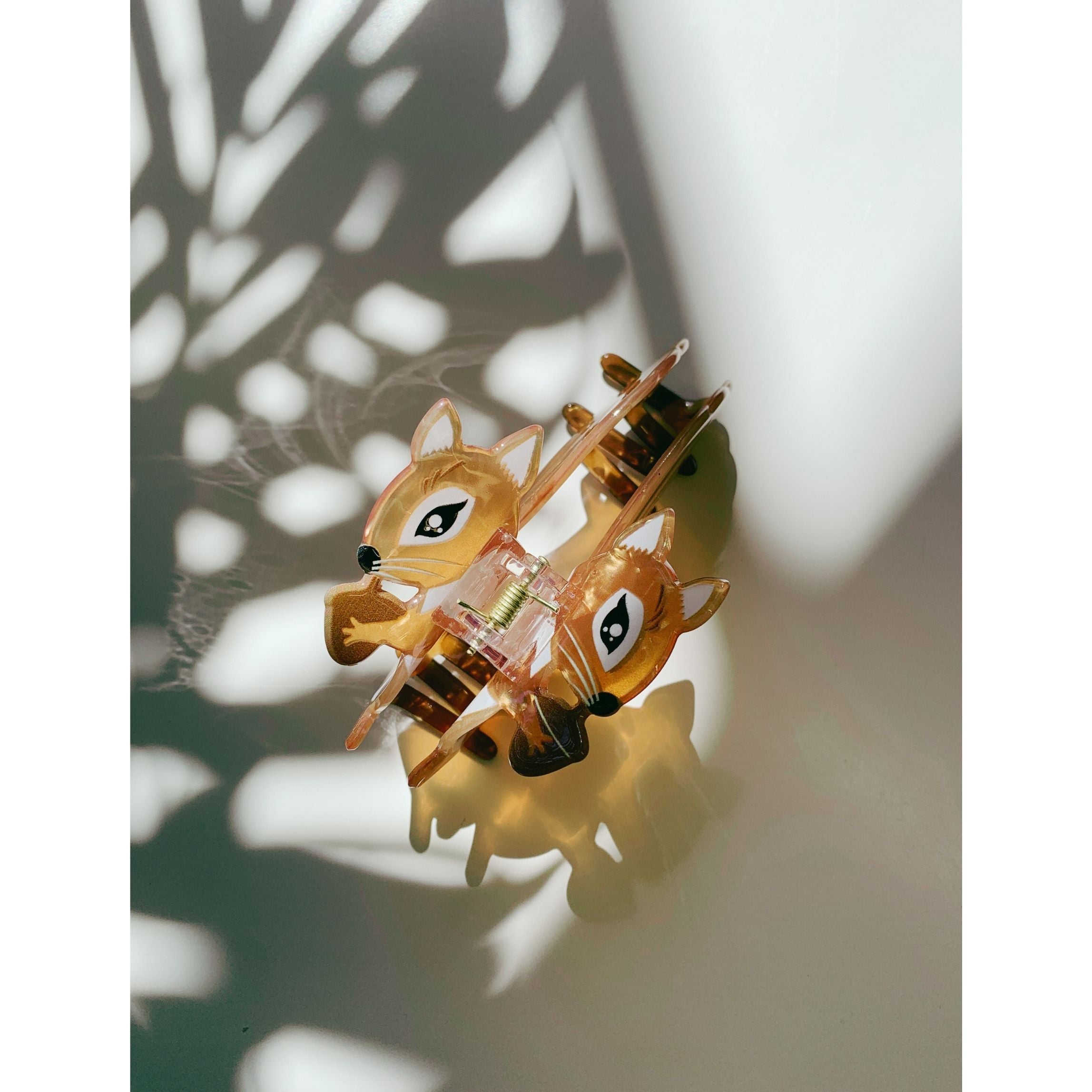 Velvet squirrel-shaped hair claw clip holding an acorn, from The Bullish Store, in a soft velvet travel bag.
