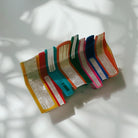 Velvet Claws Stack of Books hair clip by The Bullish Store featuring a velvet claw-style hair accessory in a travel bag.